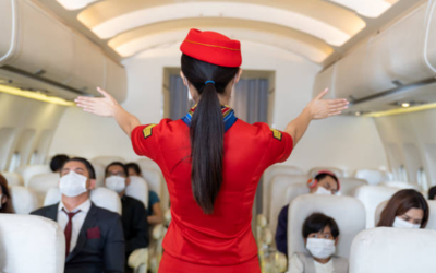 Air hostess demonstrating in-flight safety instructions to passengers during cabin service training onboard aircraft